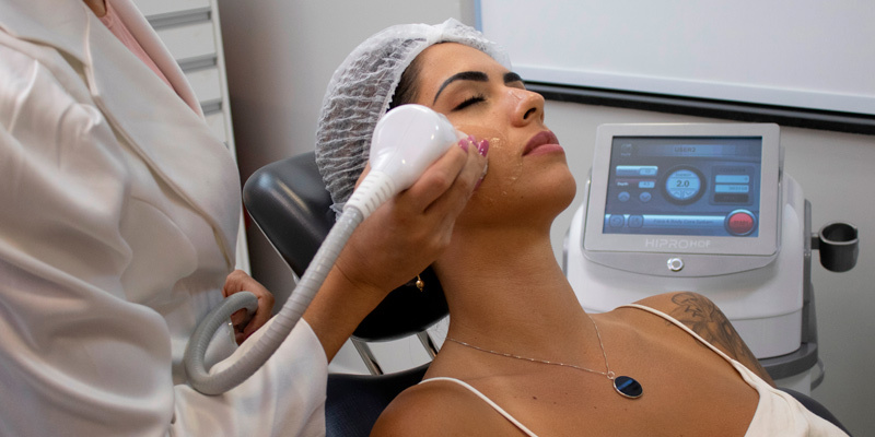 Mulher realizando HIFU no rosto durante tratamento para rejuvenescimento.